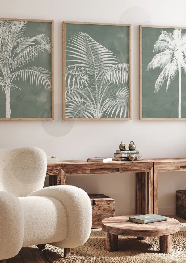 Cozy living room with a black sectional sofa, patterned pillows, a round leather ottoman, framed tree artwork, and a tall potted plant.